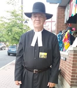 Clerical-costumed guide posing on Gettysburg sidewalk for tour