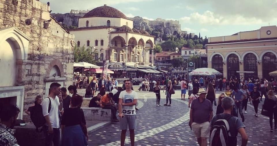 Tourists exploring ancient square and ruins in Athens