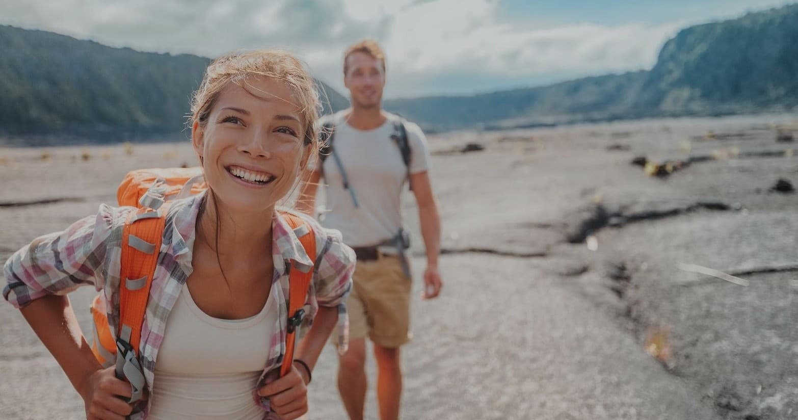 Smiling hikers trekking across volcanic lava plain on guided tour