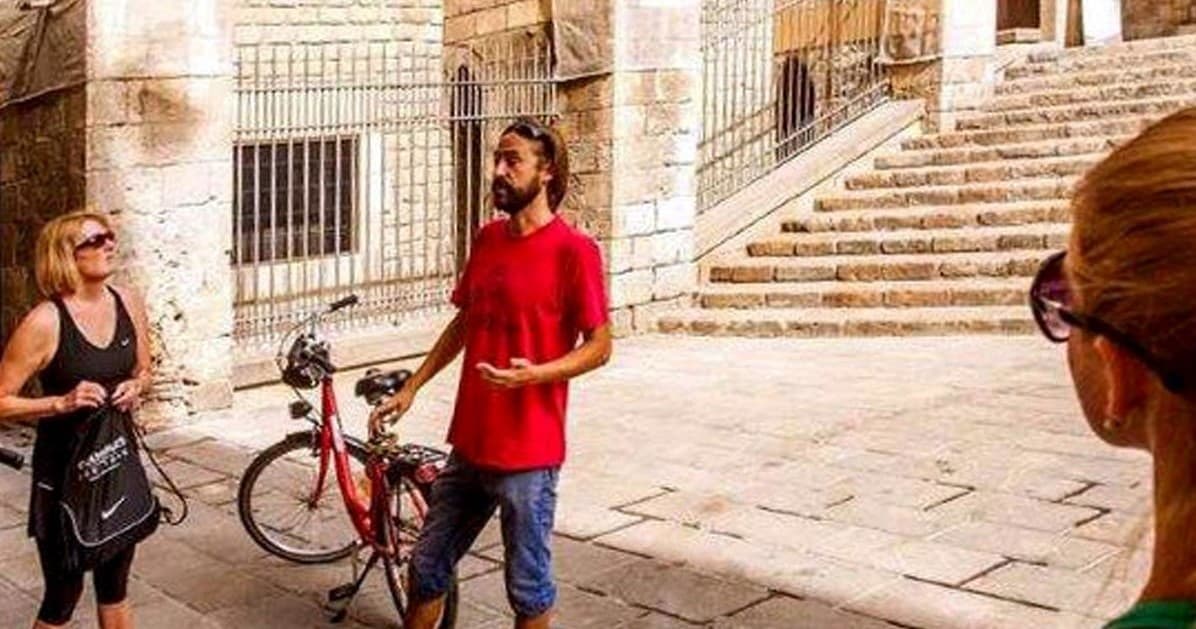 Local guide explaining sights on Barcelona bike tour near steps