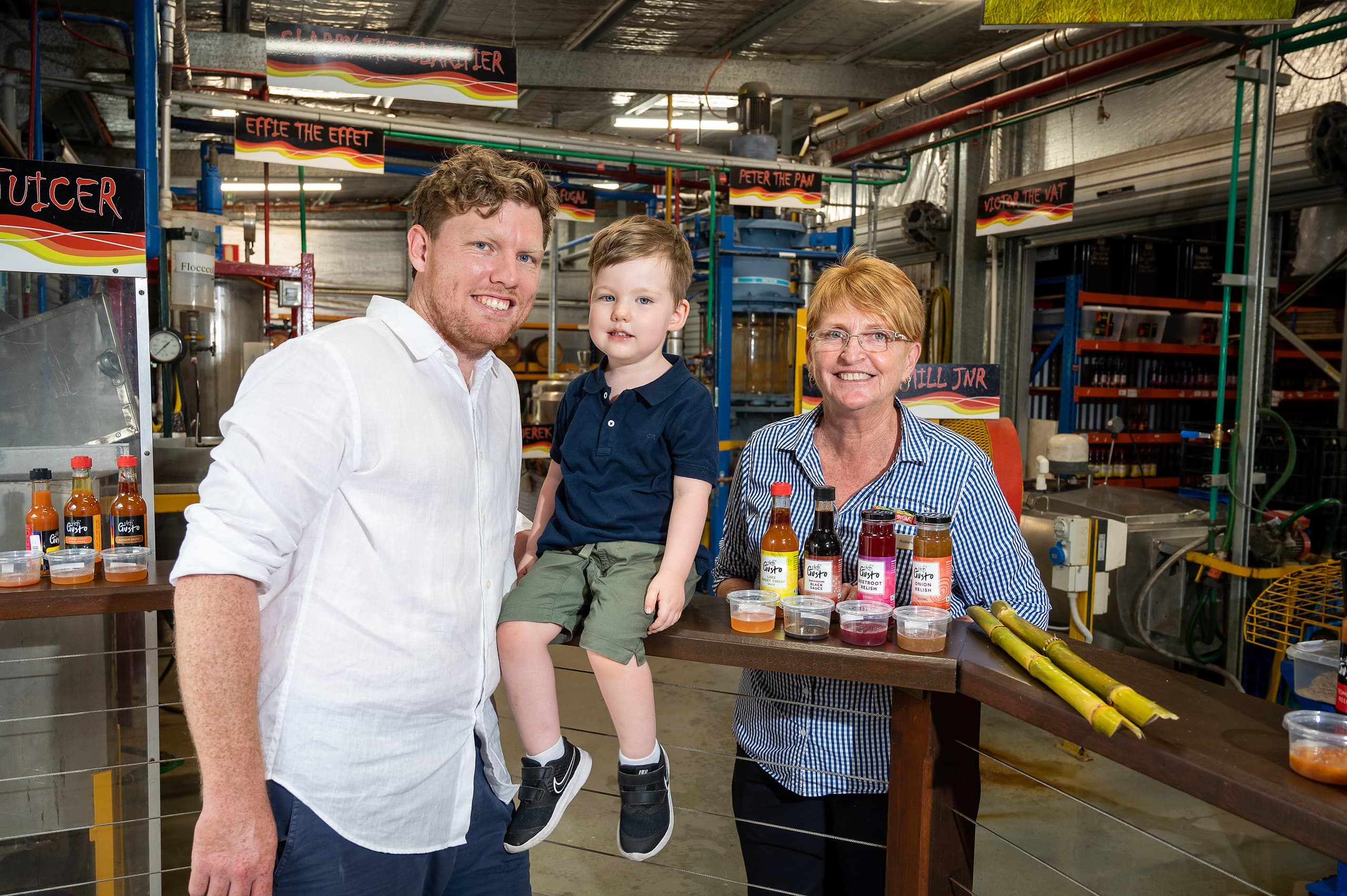 Family posing with artisanal syrups and bottles inside sugar shed