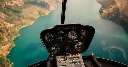 Pilot cockpit view surveying turquoise lake and river gorge