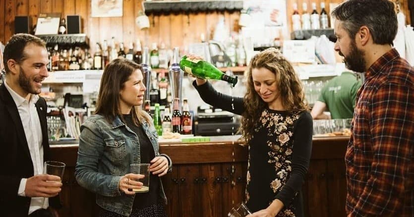 Friends enjoying craft beer tasting at rustic indoor brewery bar