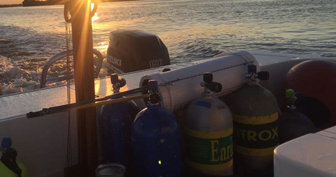 Scuba tanks on dive boat at sunset prepping for ocean dive