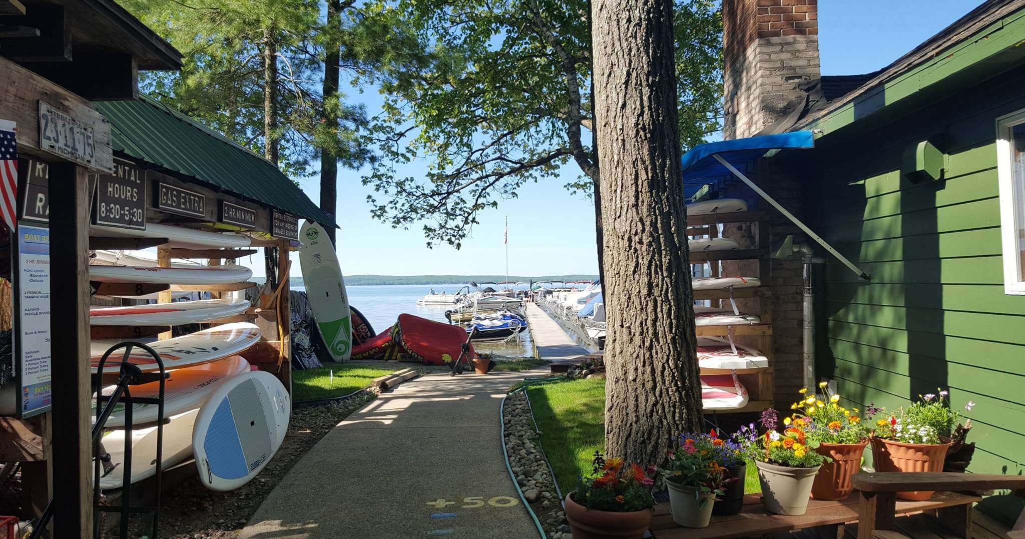 Paddleboards and kayaks lined at lakeside rental shop path