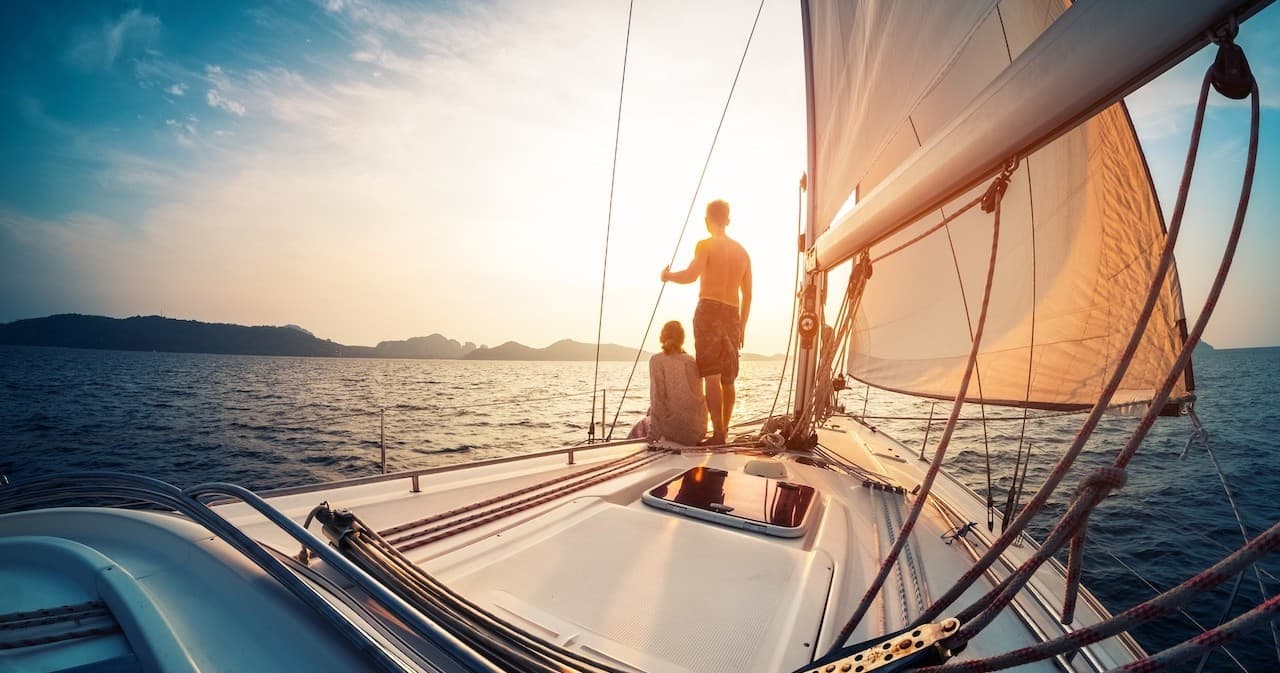 Sunset sailing near the Sicilian coast with skipper at bow