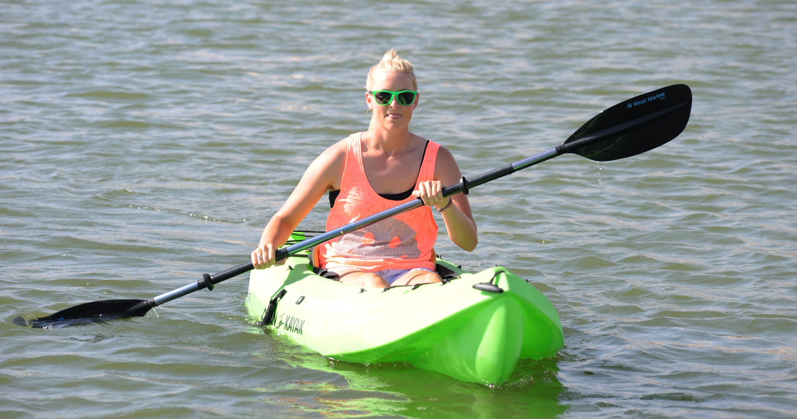 Solo kayaker paddling a green kayak across Kiwanis Lake