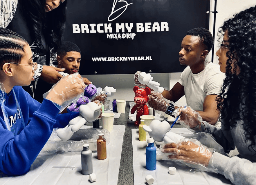 Group painting custom teddy bears in indoor workshop studio