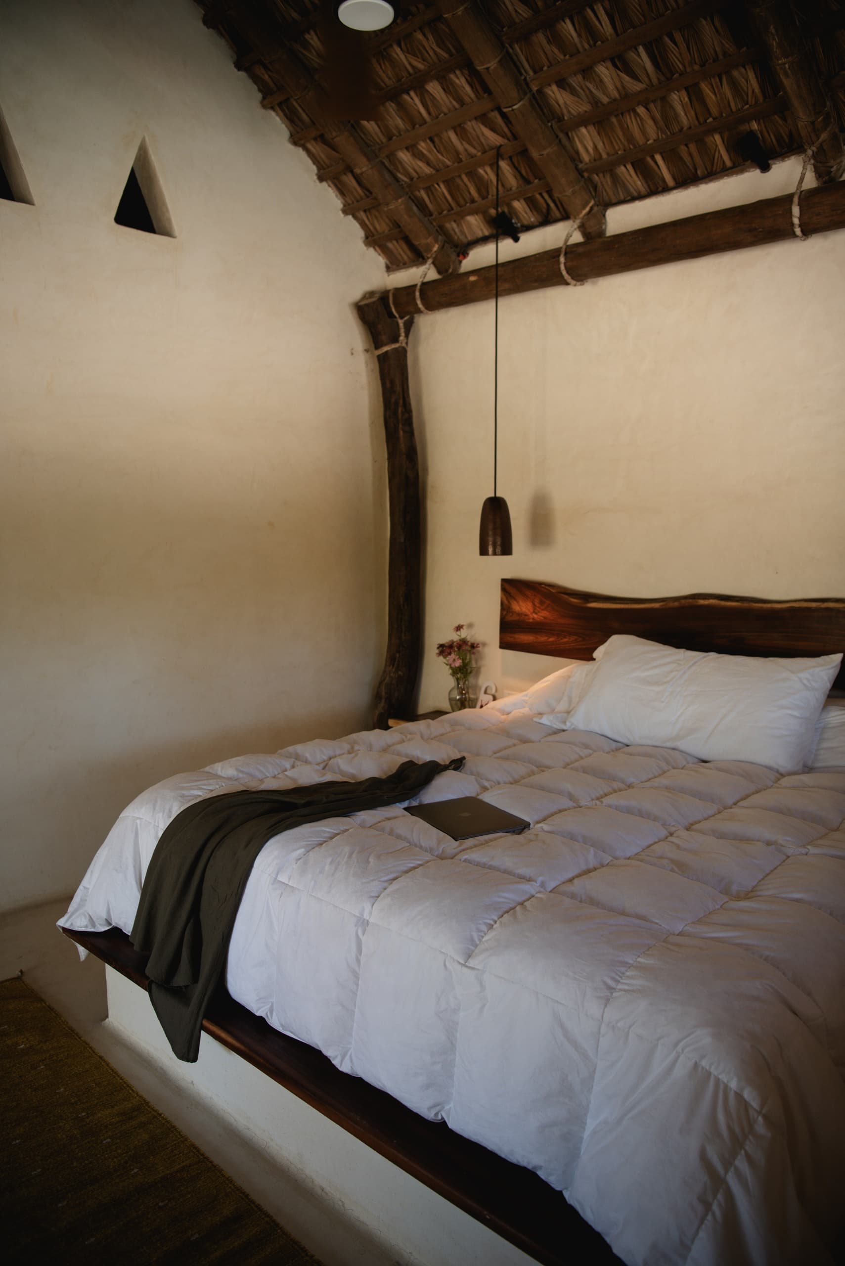Cozy thatched-roof bedroom with plush bedding in lodge