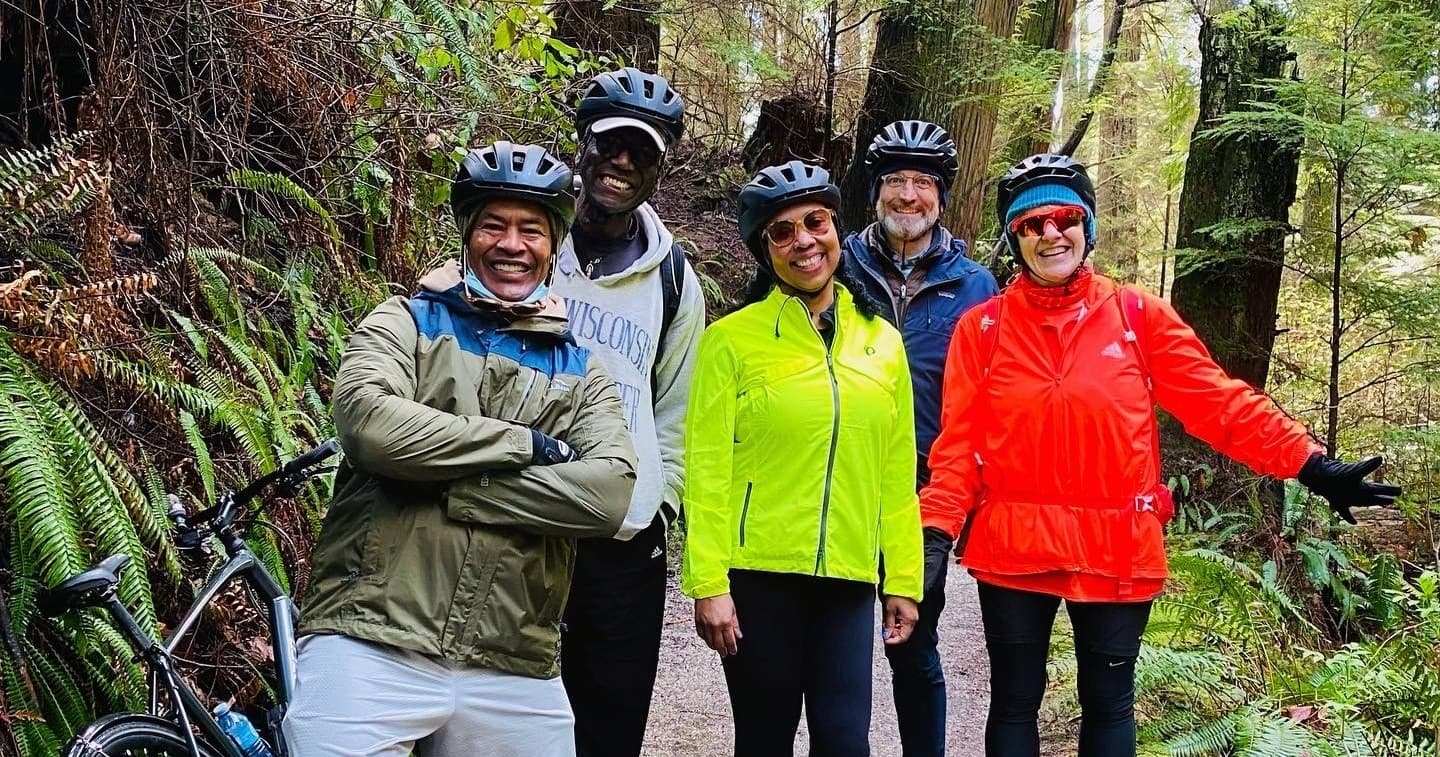 Group mountain bikers on lush Vancouver forest trail