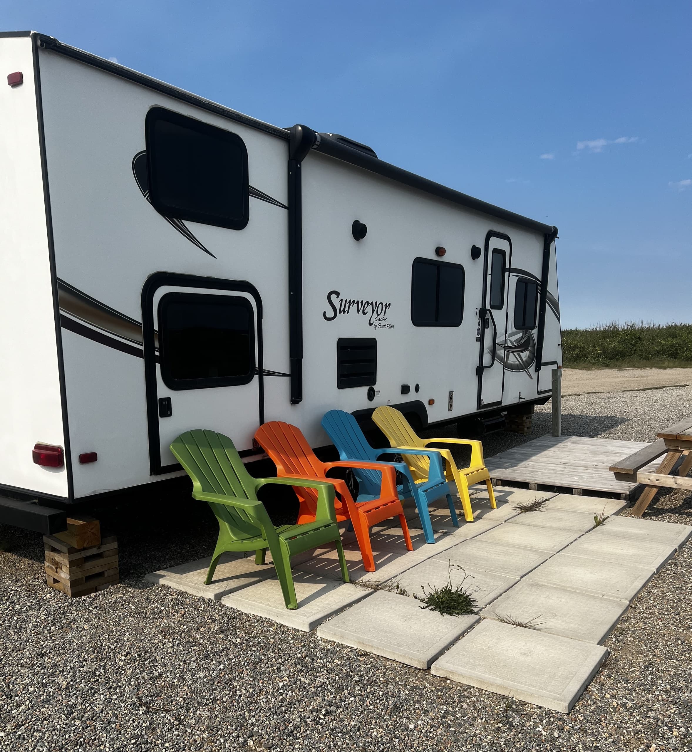 Fifth-wheel patio with colorful chairs at beach campsite