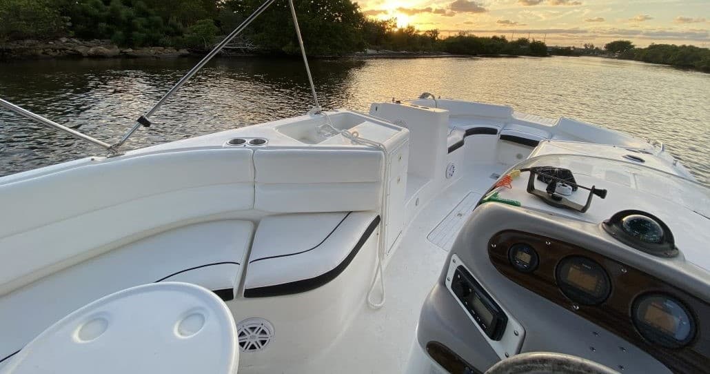 Powerboat bow at sunset on riverfront, scenic boating cruise