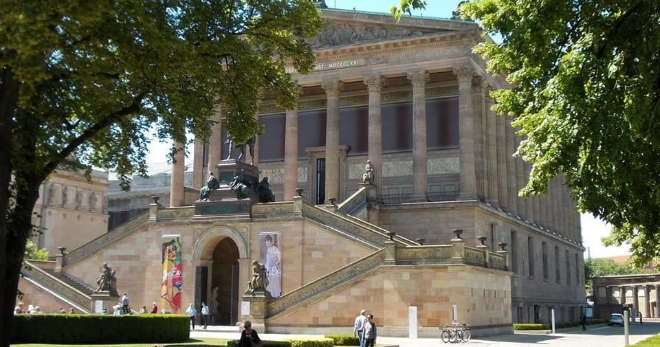 Museum exterior with grand steps and statue, Berlin landmark