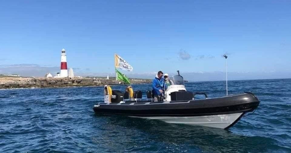 RIB charter cruising past lighthouse off Weymouth coast