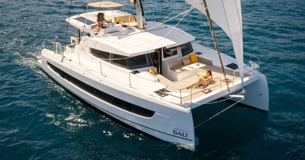 Catamaran sailing on open sea with passengers on deck