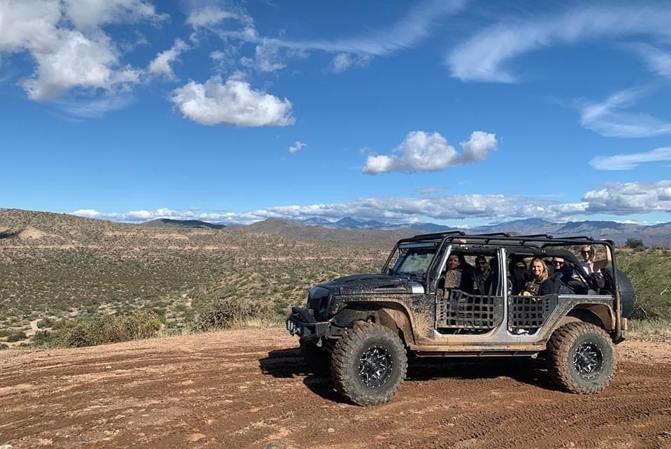 Open-top Jeep touring rugged Sonoran Desert with scenic vista