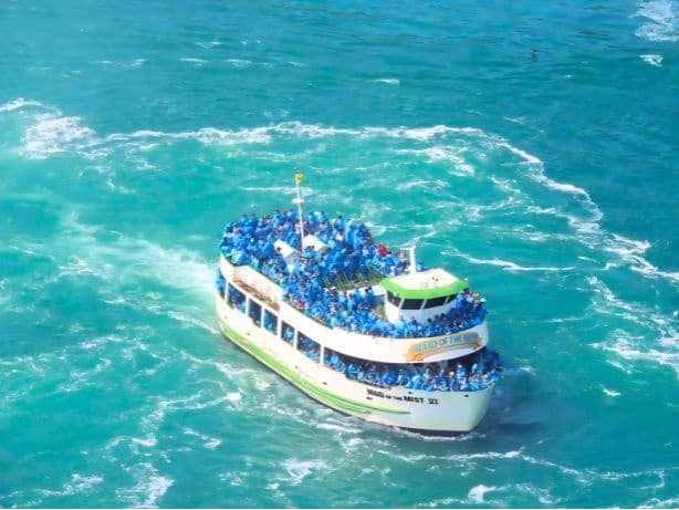 Sightseeing boat cruising turquoise rapids below Niagara Falls