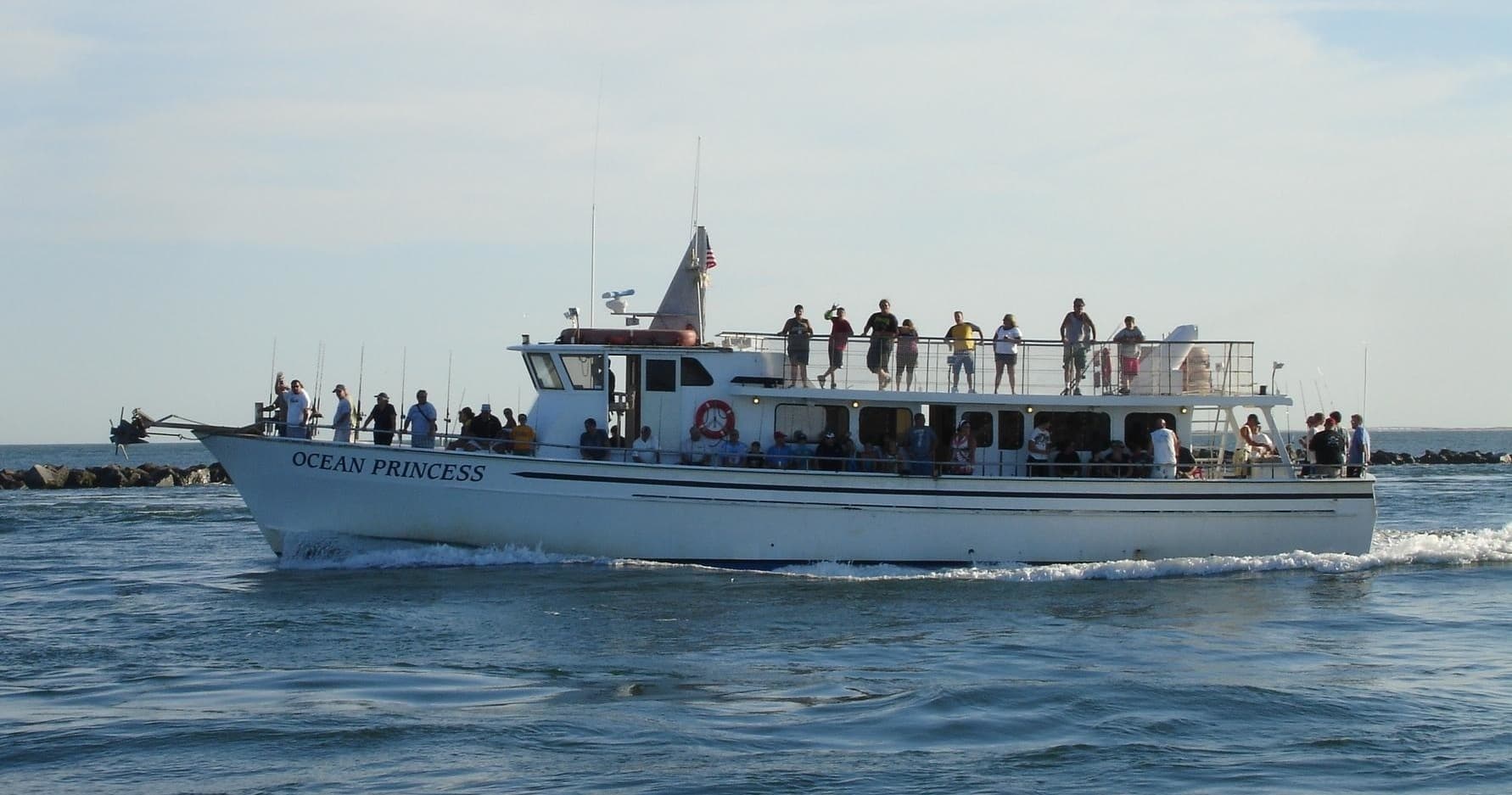 Fishing charter boat cruising with passengers on open ocean excursion