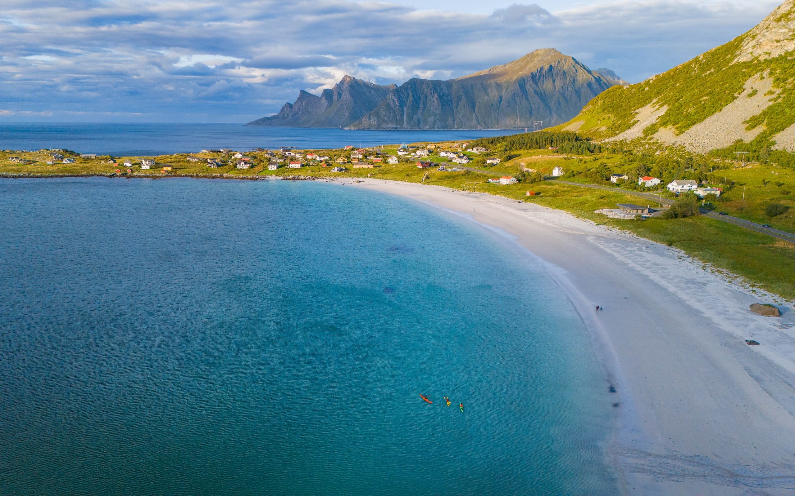 Aerial coastline with kayakers paddling along Lofoten beach