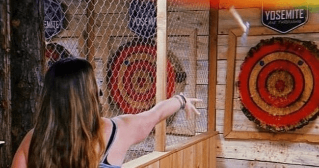 Person throwing axe at indoor Yosemite target lane