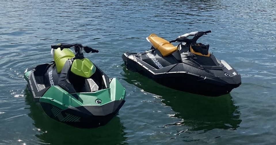 Two jet skis floating on lake water ready for rental rides