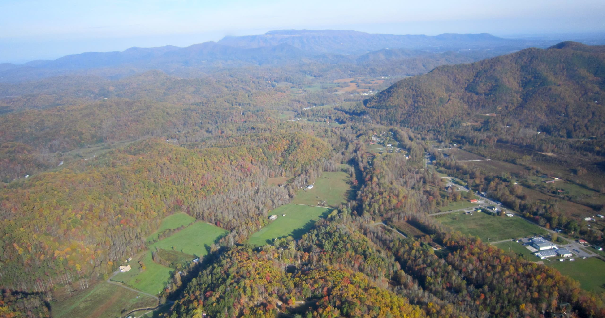 Aerial valley and farmland with winding river scenery