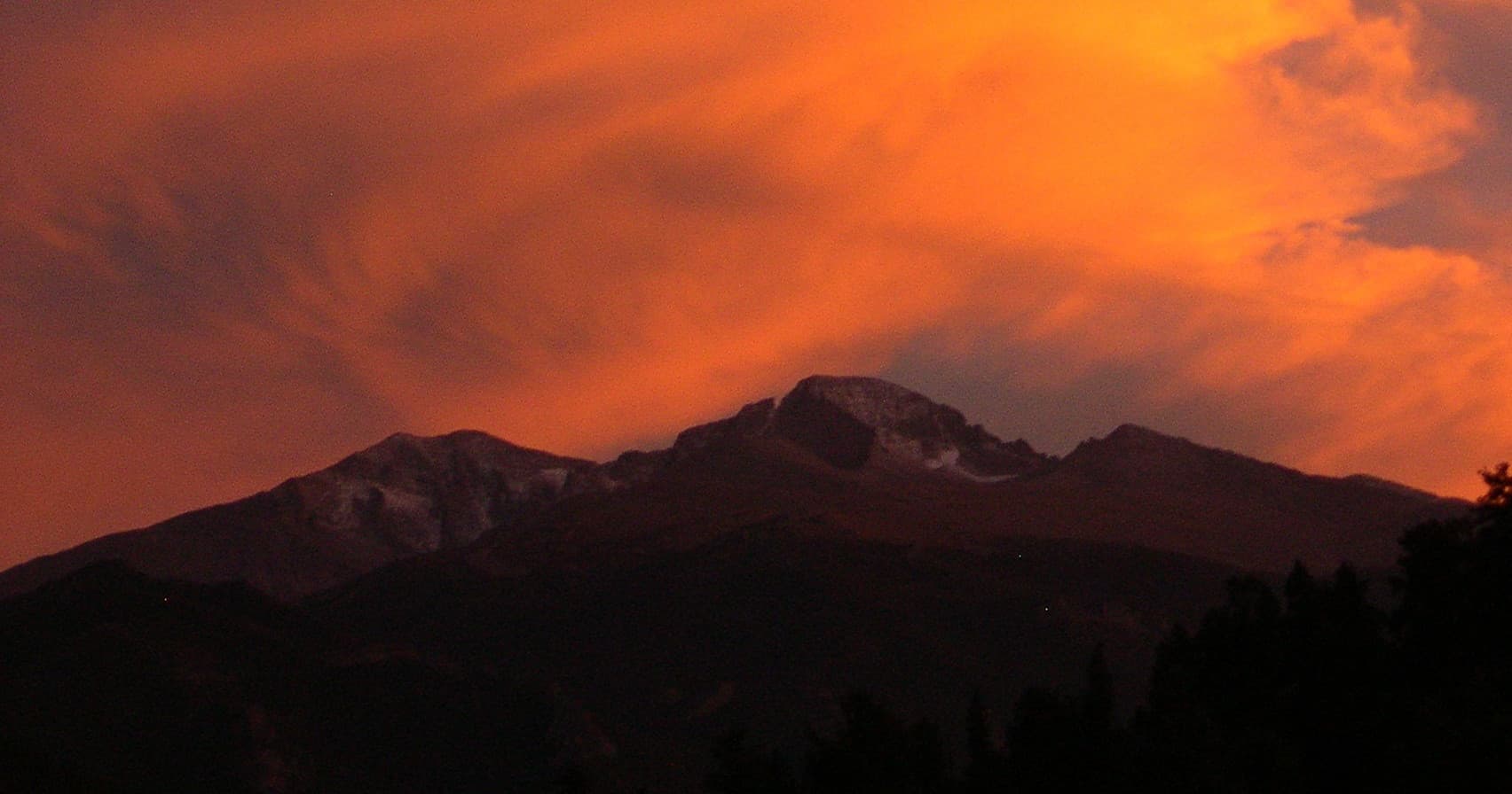 Sunset mountain vista with climbers silhouetted on rock ridge