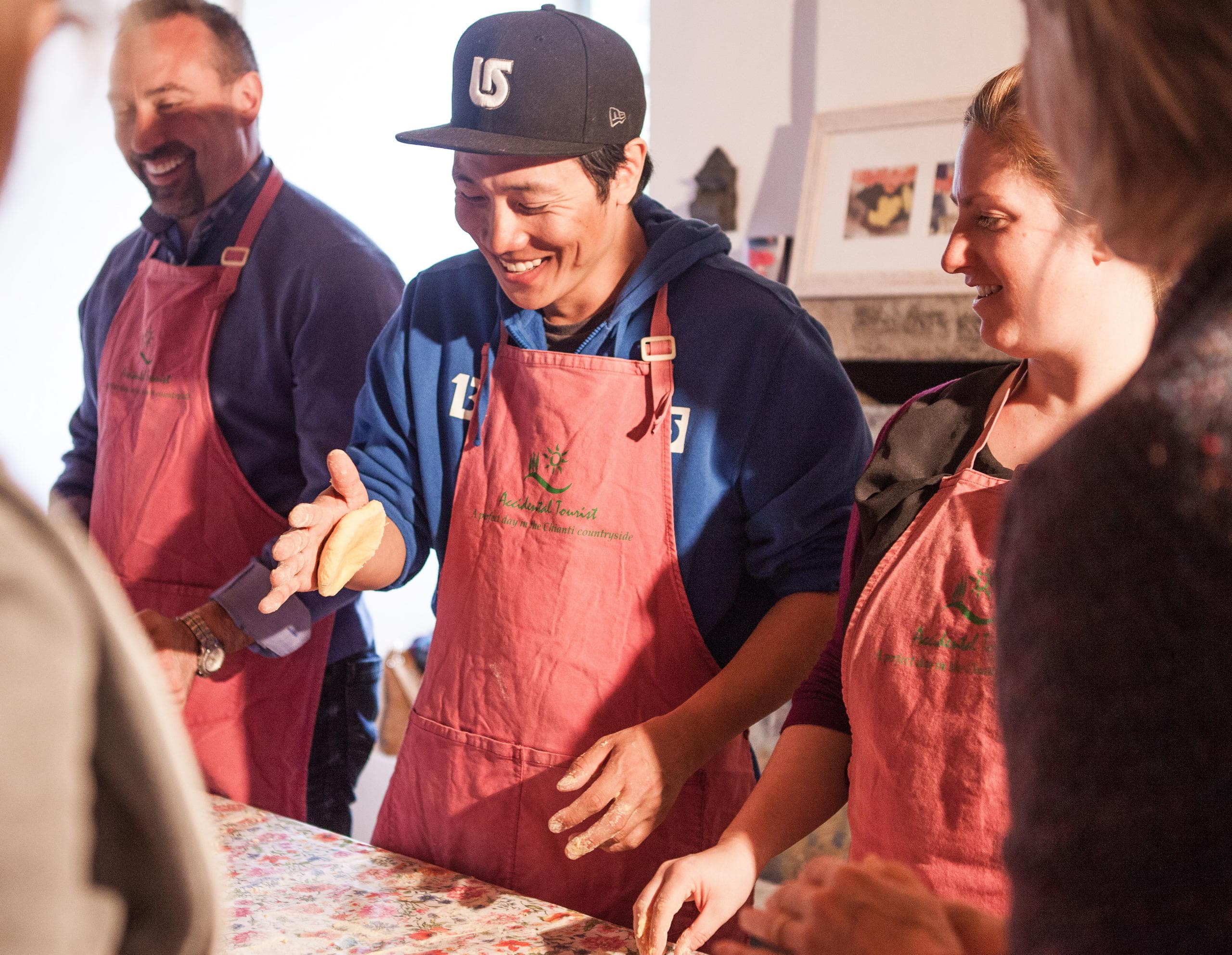 Smiling students shaping dough in intimate indoor cooking workshop