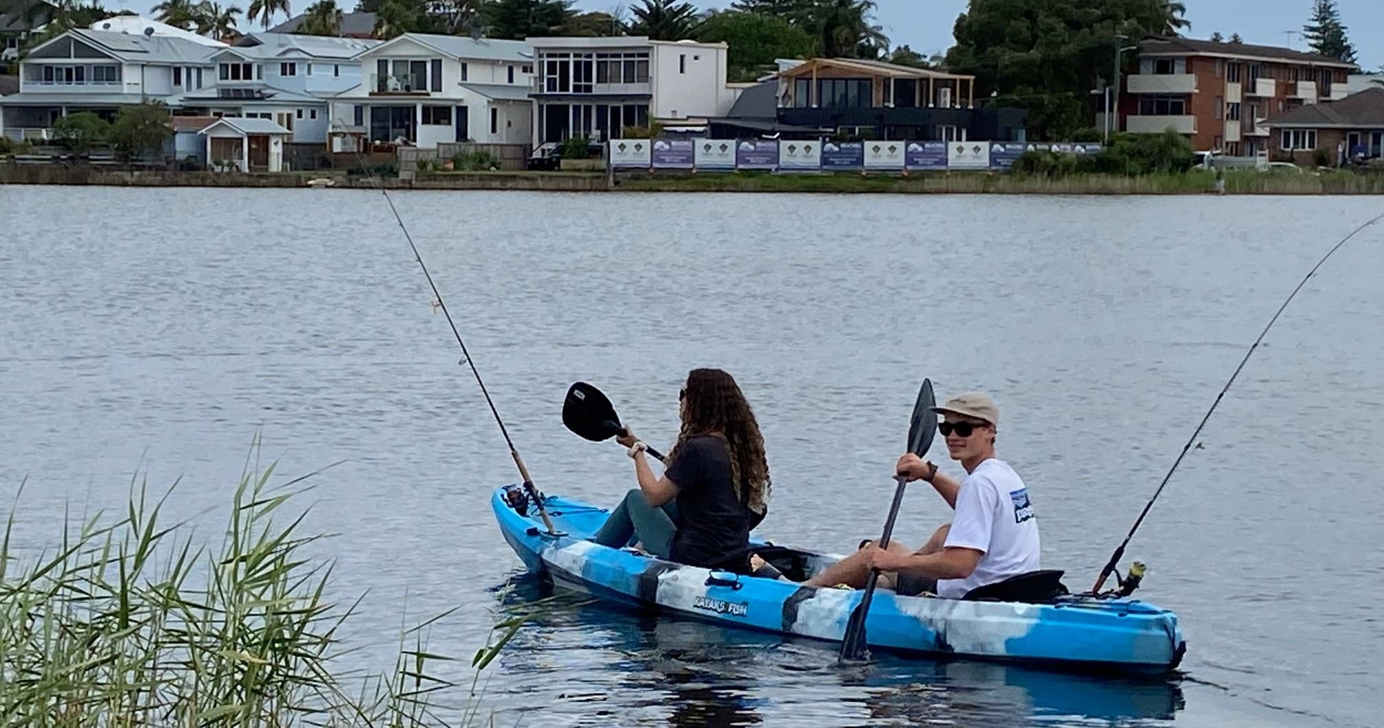 Two anglers kayaking and fishing on calm Narrabeen Lake