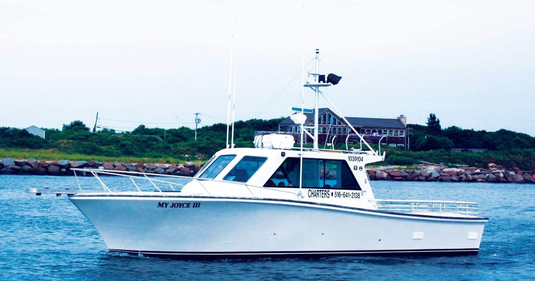 Charter fishing boat cruising coastal waters near shoreline