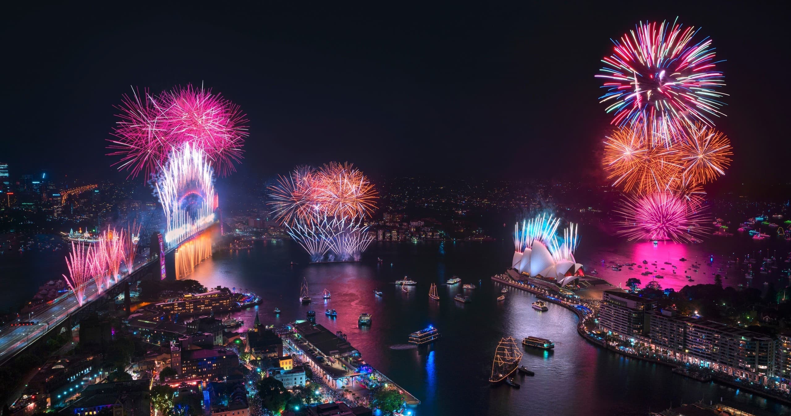 Vibrant harbour fireworks above crowded Sydney marina at night