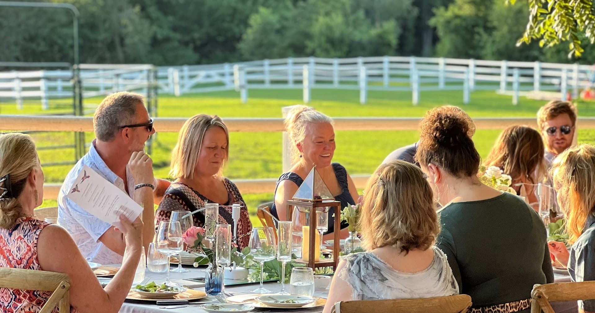 Outdoor farm-to-table dinner on ranch patio with sunset