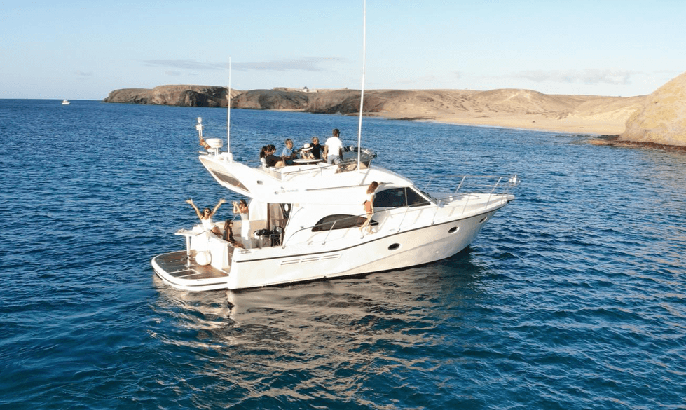 Motor yacht cruising coastal waters near rocky desert shore
