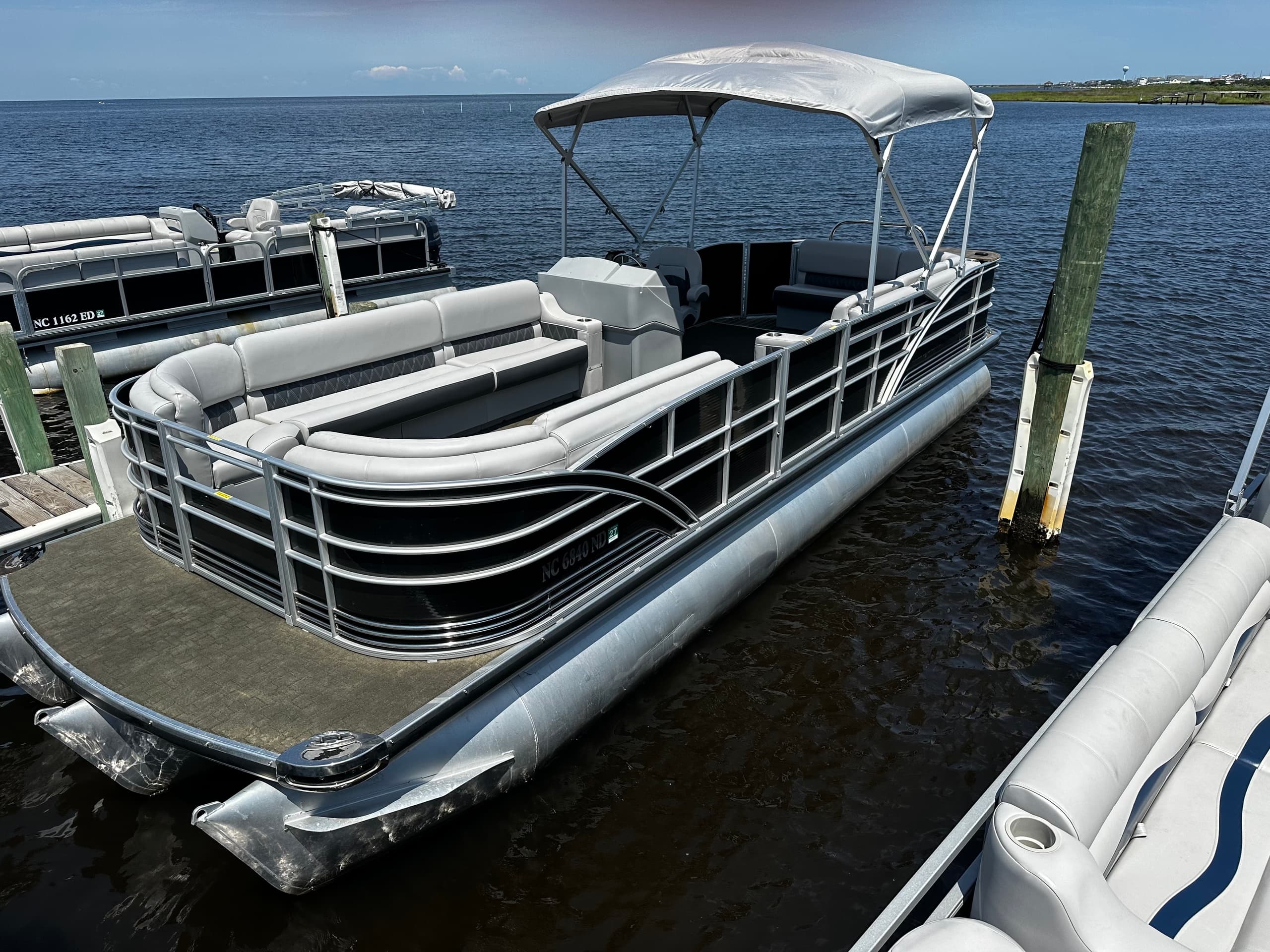 Luxury pontoon docked with calm waters and clear sky backdrop