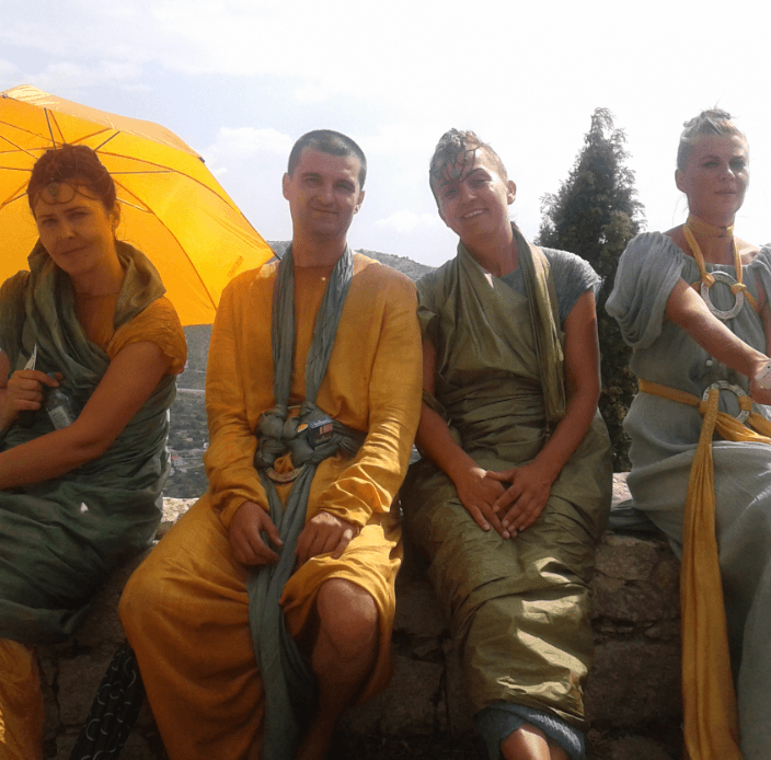Performers in historical costumes seated outdoors at festival