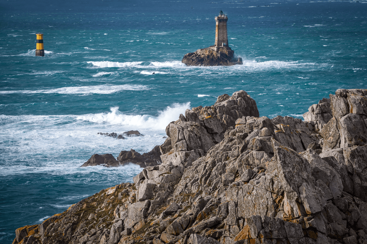 Rocky coastline with lighthouse and crashing ocean waves
