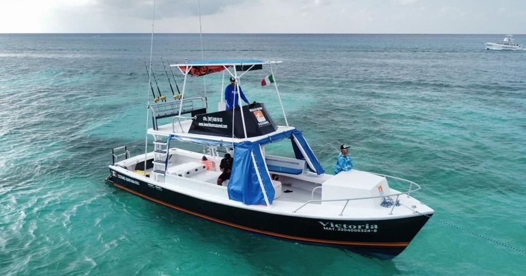 Small tour boat cruising turquoise open sea near reef