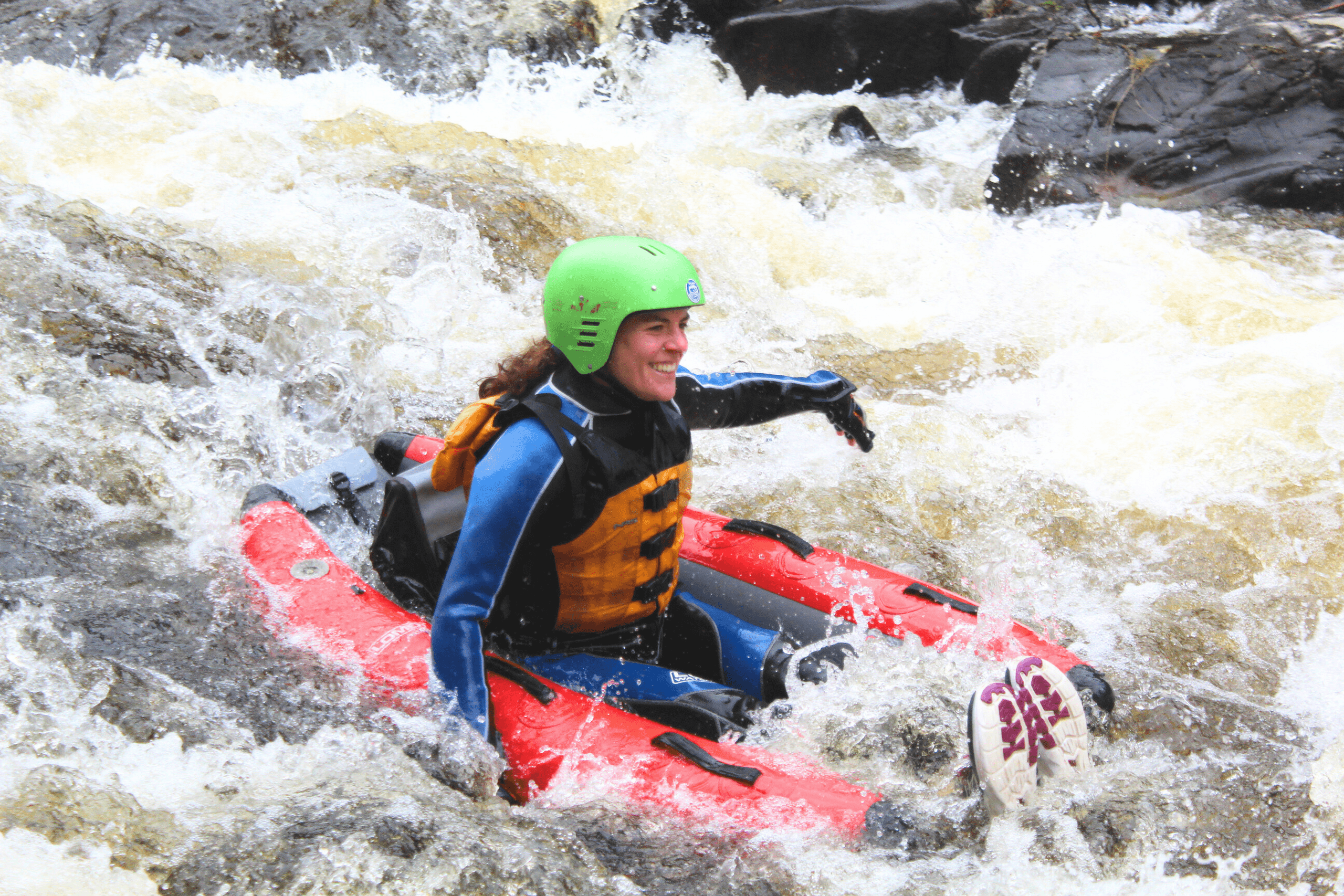 Solo whitewater kayaker paddling through turbulent river rapids