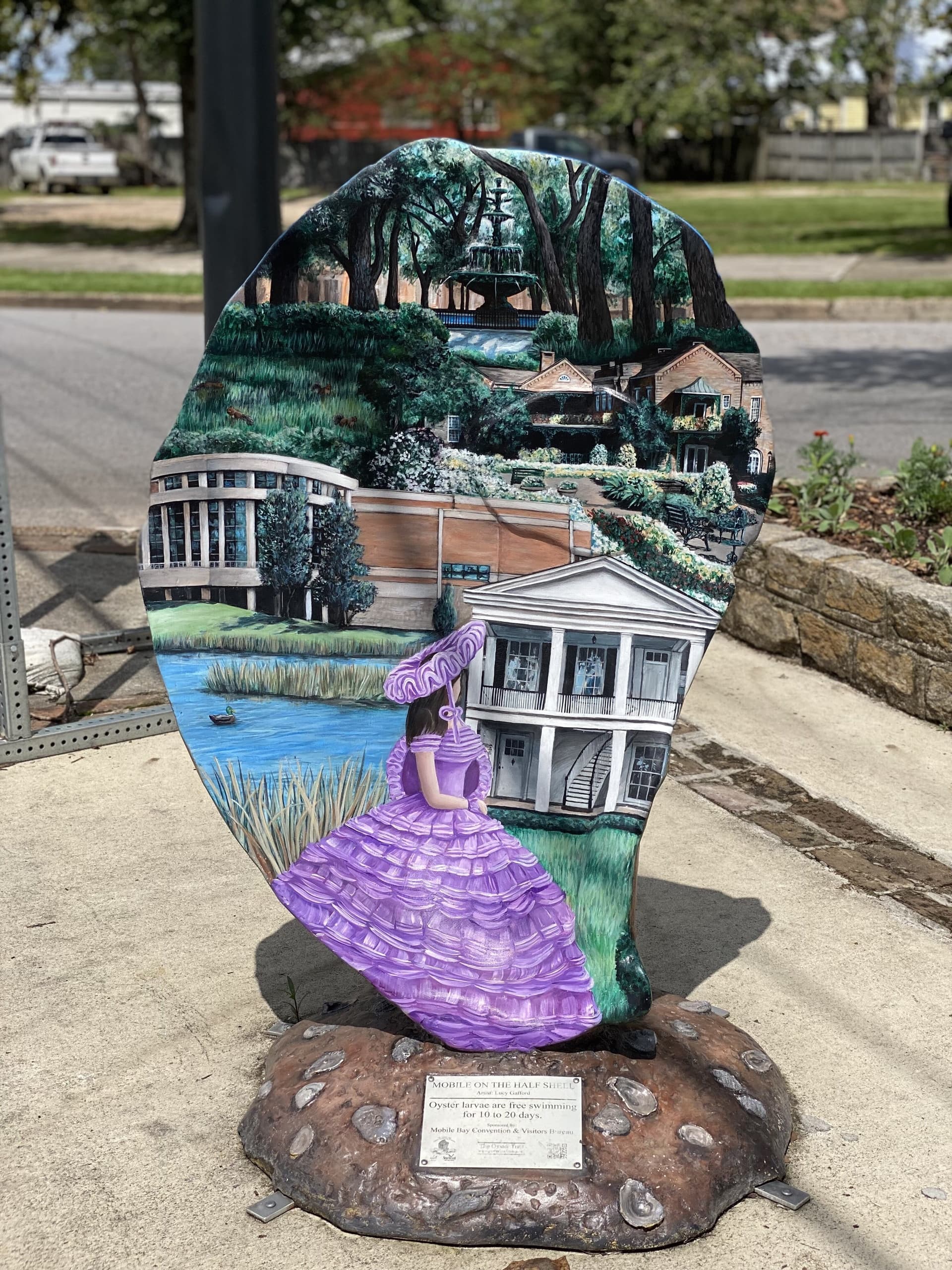 Painted outdoor sculpture on sidewalk showcasing local landmarks
