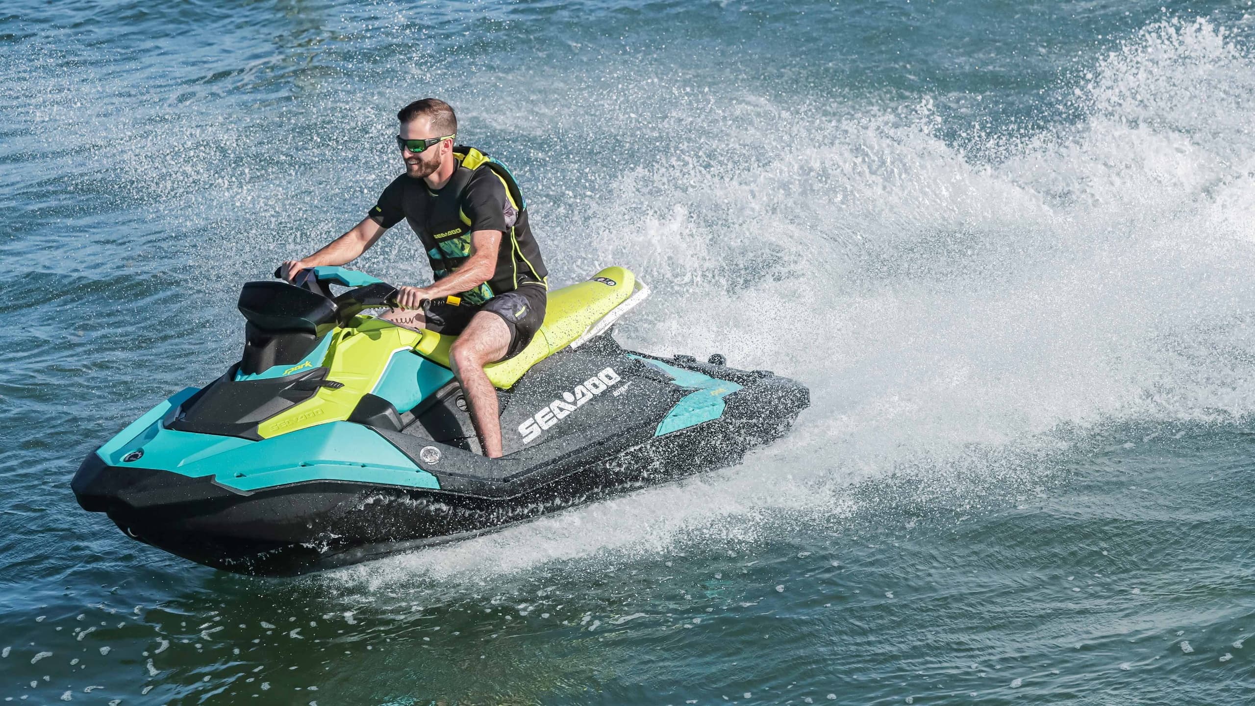 Rider on jet ski speeding across coastal waters with spray