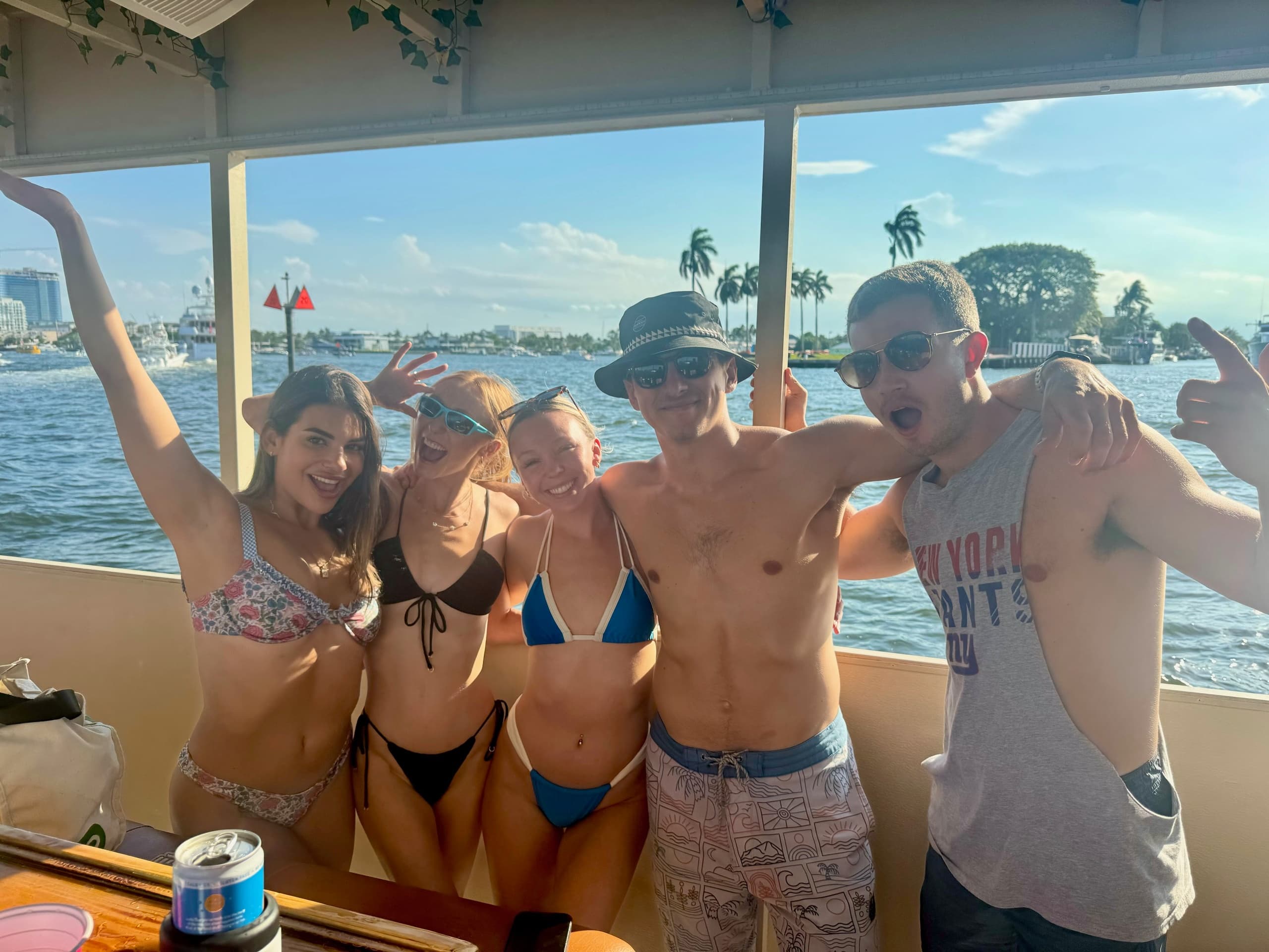 Friends posing on deck of party boat in coastal inlet