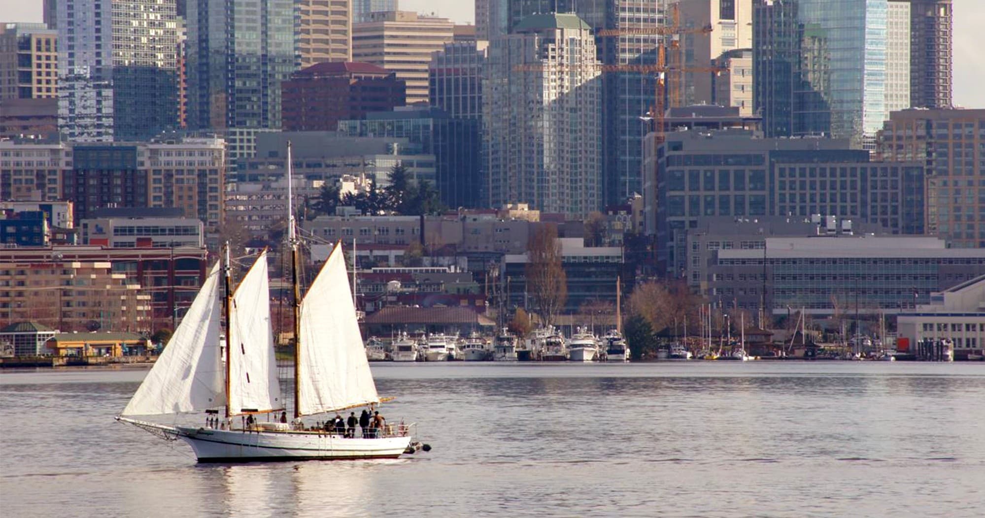 Two-masted schooner cruising near Seattle skyline on Lake Union
