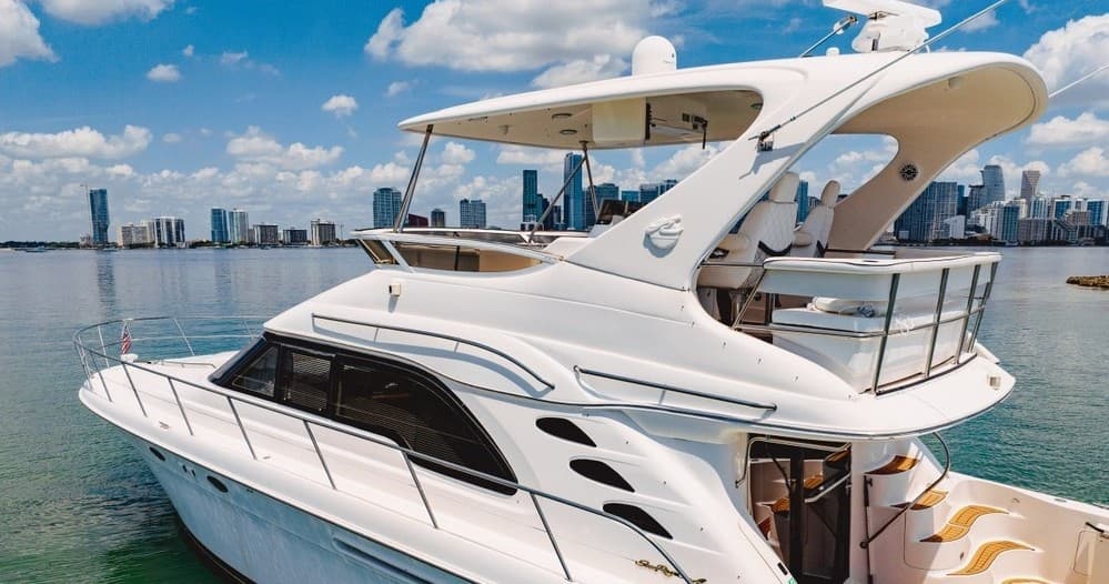 White luxury yacht deck with city skyline and sunny harbor view