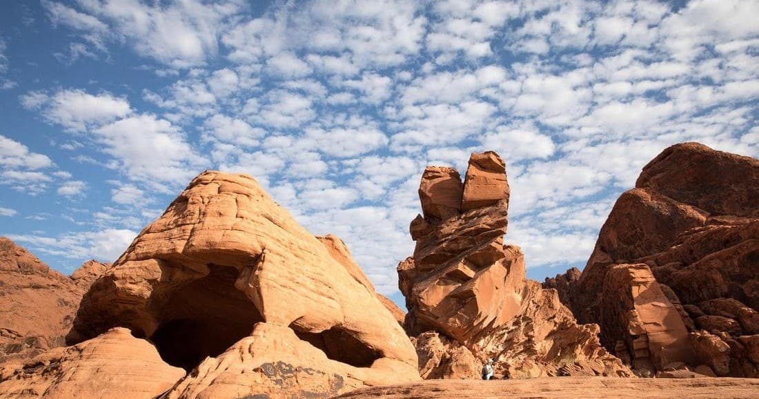 Sculpted red sandstone formations under textured sky, desert view