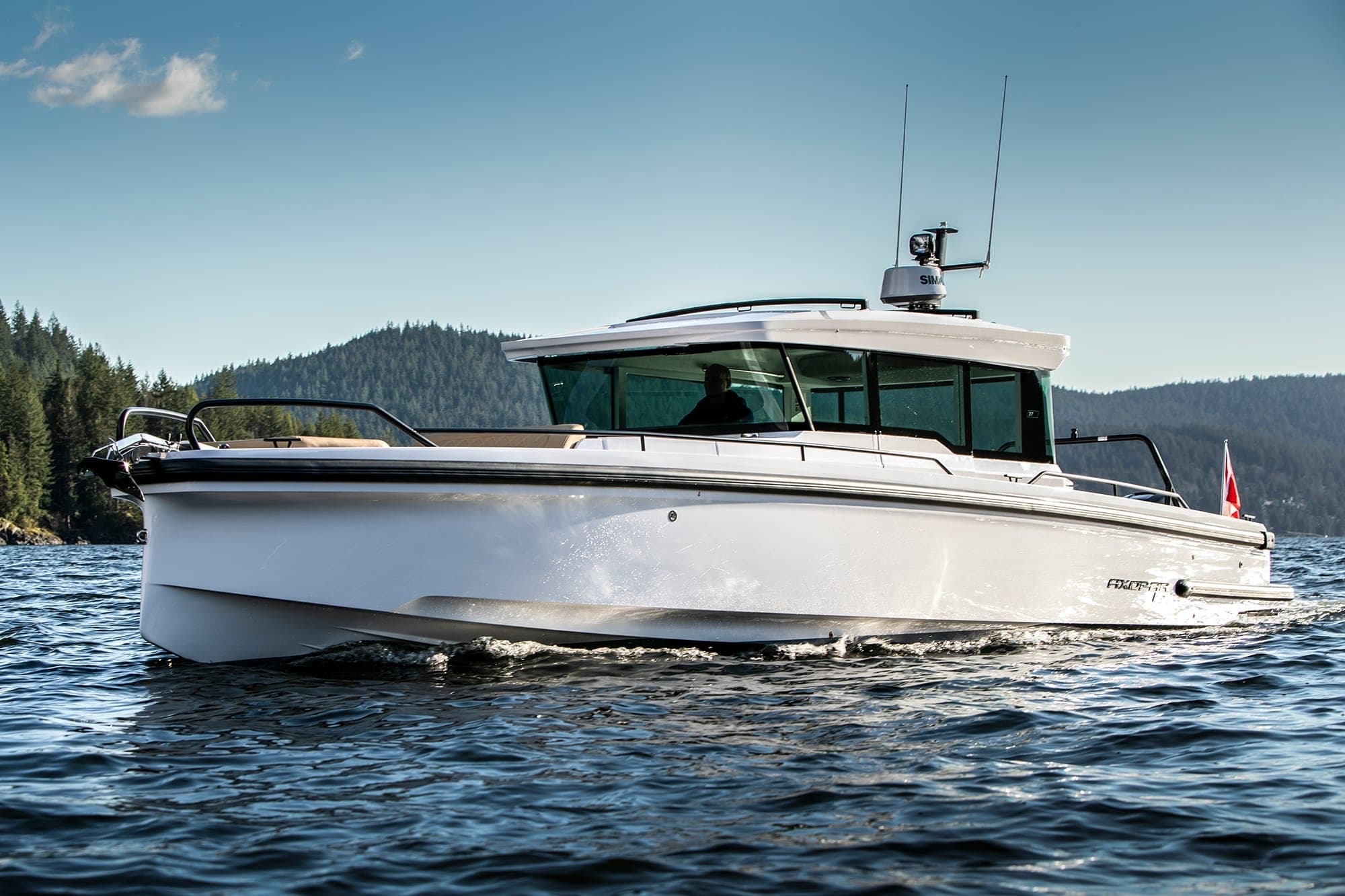 Motorboat cruising coastal waters near forested island shoreline