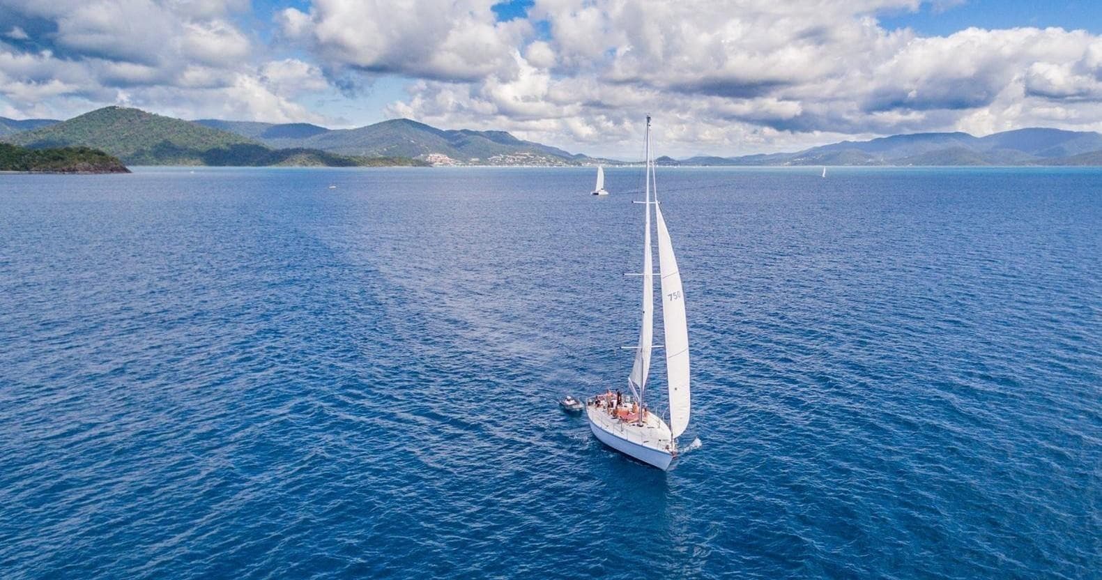 Solo sailboat cruising calm ocean with space for overlay