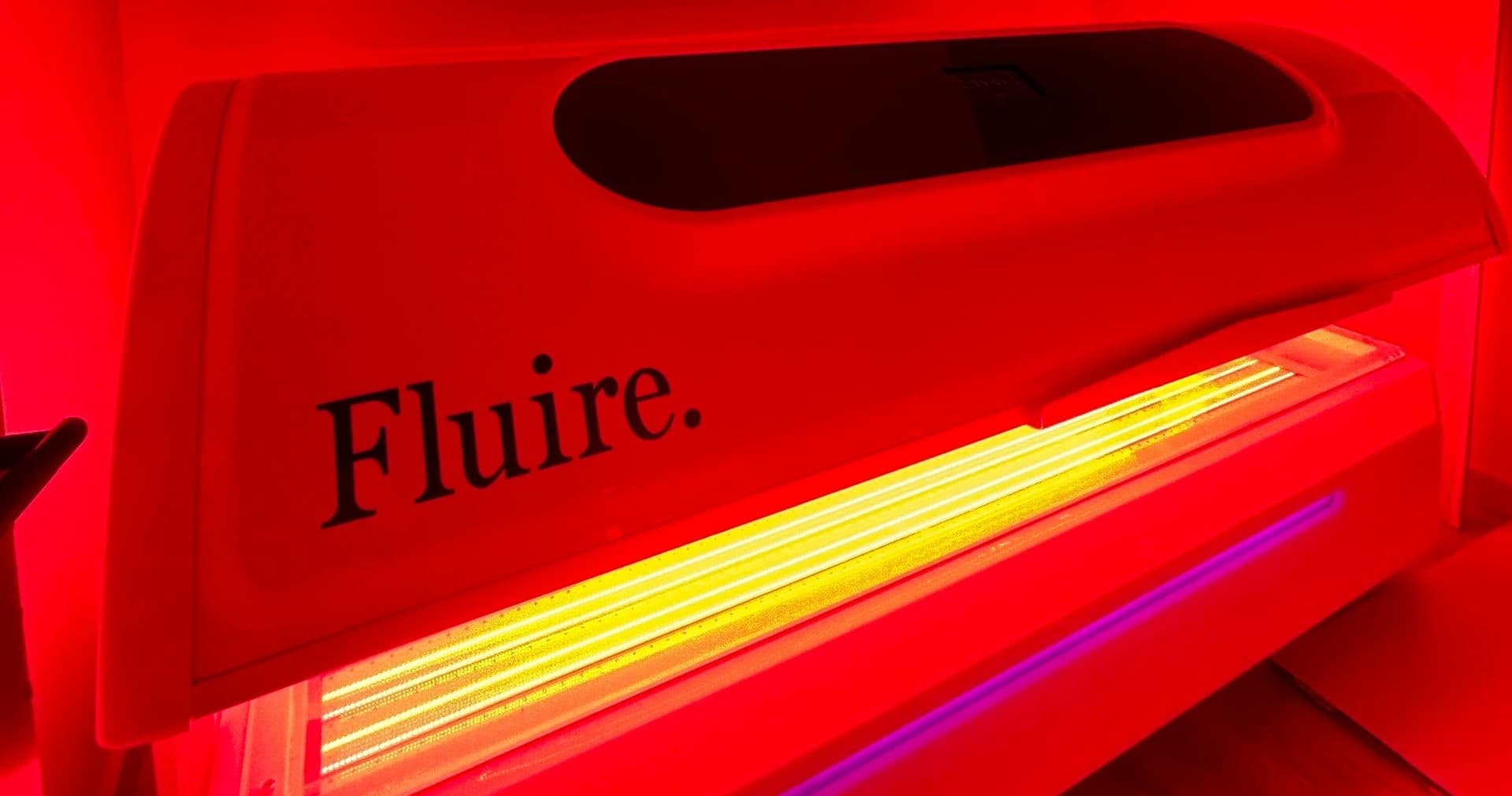 Red light therapy bed glowing in indoor recovery studio