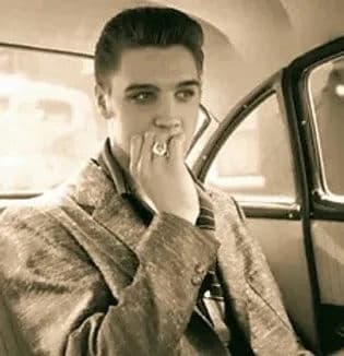 Retro portrait of singer seated in classic car during road trip