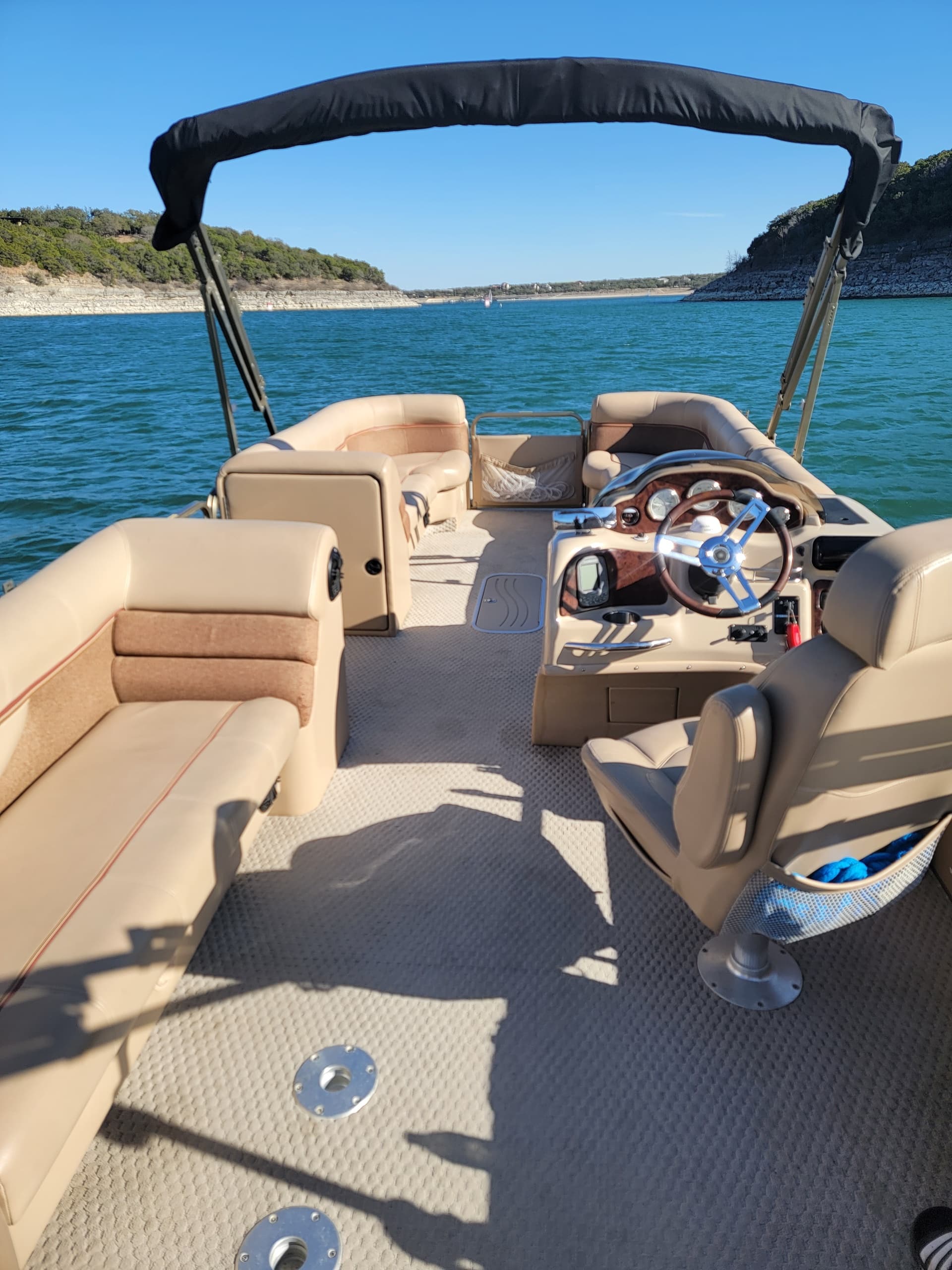 Pontoon boat interior and helm on clear lake day at reservoir