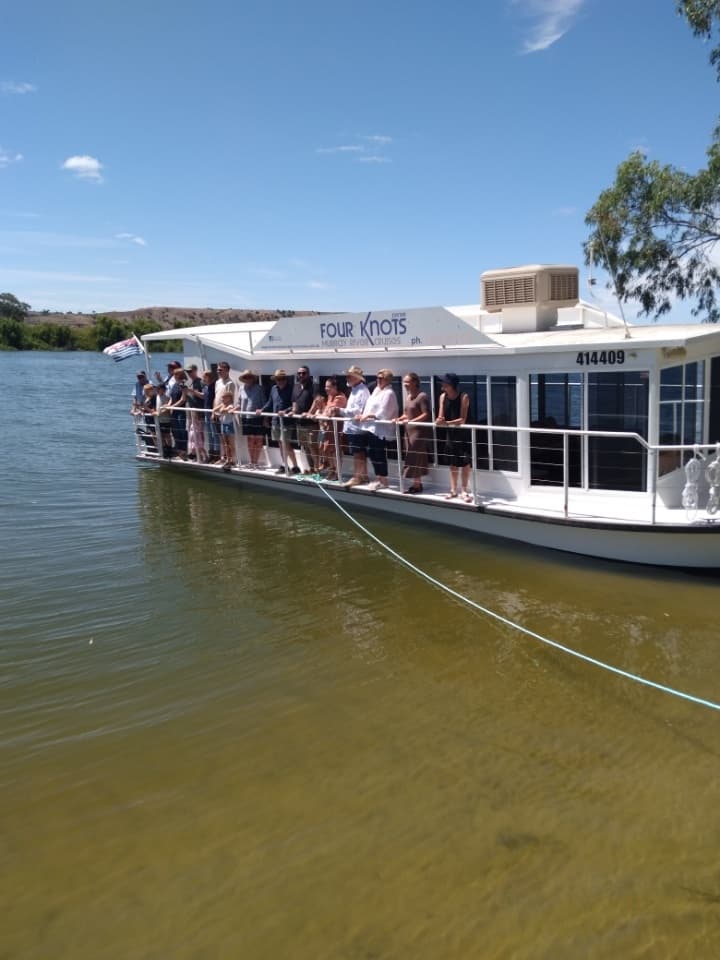 Crowded sightseeing cruise boat docking on Murray River shoreline